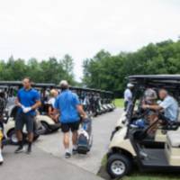 Group of alumni by golf carts
